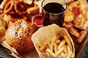 comida chatarra y poco saludable. diferentes tipos de comida rápida en la mesa, primer plano foto