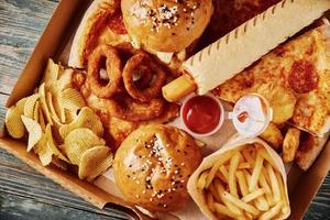 Unhealthy and junk food. Different types of fast food on the table, closeup photo