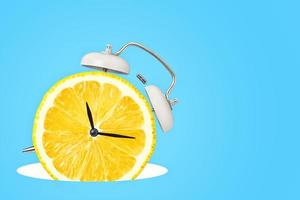 Creative concept. Clock with lemon dial on blue background photo