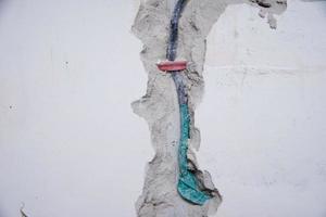 Old electrical cables in a brick wall. Danger wiring photo