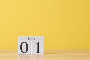 Wooden block calendar with date May 1 on the yellow background photo