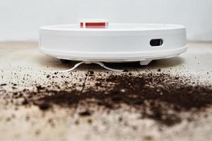 Robot vacuum cleaner cleans dirt on floor. Smart home concept photo