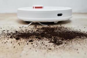 Robot vacuum cleaner cleans dirt on floor. Smart home concept photo