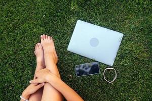 Young fit attractive woman lying on green lawn park. photo