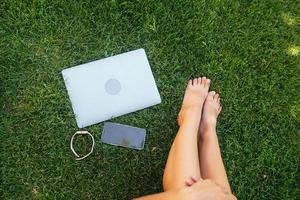 Young fit attractive woman lying on green lawn park. photo