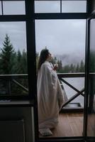 Woman drinking tea on cozy balcony of a country house. photo