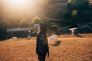 una pastora pasta cabras en un prado foto