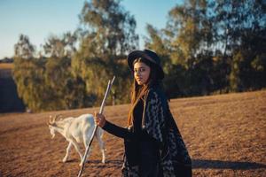 una pastora pasta cabras en un prado foto