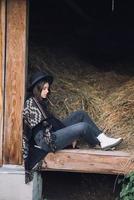 Young brunette woman sitting at the barn. Country style. photo