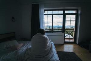 Young woman wrapped in a blanket staring into the distance photo