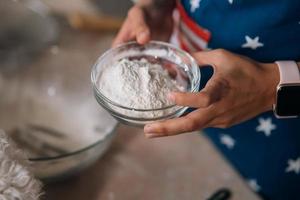 Close-up of female hands holding flour in a bowl. photo