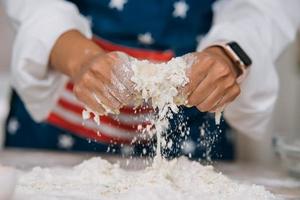 Young housewife in an apron kneads dough with her hands. photo