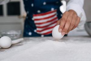 Girl confectioner holding chicken egg in her hand photo