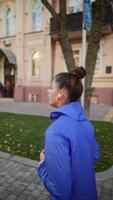 Rear view of an adult woman running outdoors on a street photo