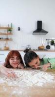 Two beautiful women play with flour in the kitchen photo