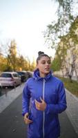 Front view of beautiful woman is jogging outdoor autumn day. photo