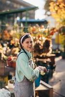 mujer campesina feliz con overoles de mezclilla sonriendo sinceramente mientras posa. foto