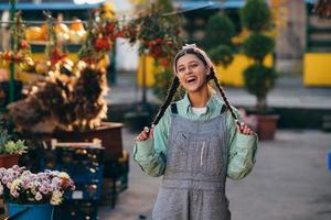 Playful farmer woman in denim overalls smiling sincerely while posing. photo