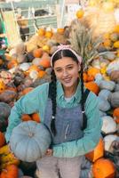 agricultora sosteniendo calabaza en el fondo de la cosecha de otoño. foto