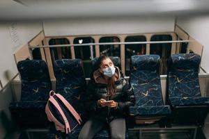 Young woman with mask traveling in the public transport. photo