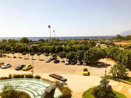 view of the green city from above. park, trees and shrubs at the seaside resort. cars, barriers of the country are visible at a height photo