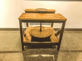 Museum piece. ancient loom for weaving from natural wood. circle for winding threads and fabric. table and seat for a person working with his hands photo