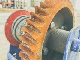 metal, rusty and old reel with a wound electric cable. construction site. orange rust from water on a metal circle. cable for electricity supply photo