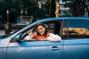 mujer feliz en un auto, mirando por la ventana. foto