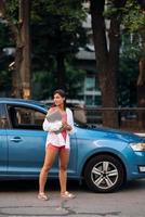 mujer joven caminando al aire libre sosteniendo una computadora portátil foto