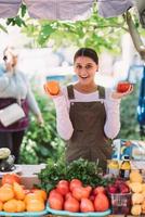 Young saleswoman holding home-grown tomatos in hands photo