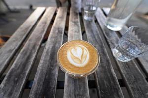 Cup of cappucino are the wooden table. photo