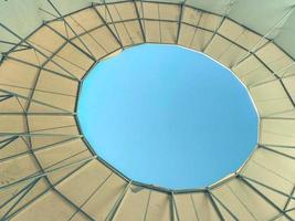 roof made of fabric, awning, waterproof material with a hole. view of the blue sky from above. hole in the balloon. dense material dome photo