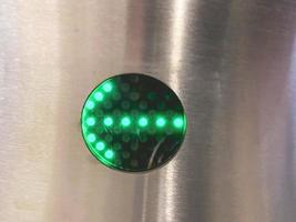 escalator in the underpass. rise to different metro stations. next to the escalator, the green arrow is a neon direction indicator on the turnstile. green neon photo