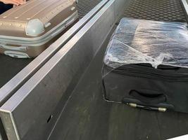 passenger luggage on a conveyor belt in the baggage claim room photo
