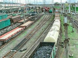 railroad in the city. metal rails. on the road are freight, red freight wagons, large and capacious wagons transport black bulk coal to other countries photo