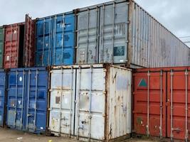 Multi-colored iron industrial sea containers for international transportation of goods according to the logistic rules of Incoterms 2010 DAP and DDP photo