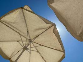 white umbrellas against a blue sky photo