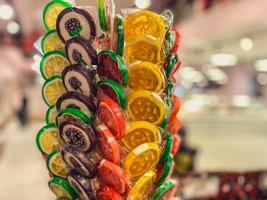 many small, multi-colored flavored lollipops in a candy box. Turkish sweets for sale. lollipops with a berry inside. caramel in a wrapper. sweet candy on a stick photo