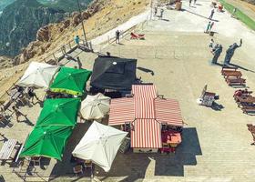 vacation at the top of the mountains. on the observation deck entertainment for tourists. small tents under the roof with food, activities. nearby wooden tables and benches for guests to relax photo