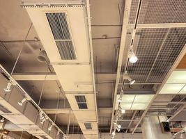 ceiling in a new building. shopping center in a loft style. metal sheet on the roof, long modern and stylish lamps are attached to the ceiling. bright room photo