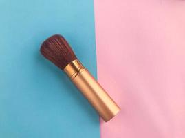 powder brush on a bright pink and blue background. creating a matte texture on the face. powdery texture, beautiful and even skin photo