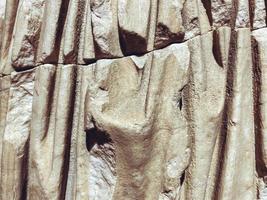 ancient texture. a stone of beige color, a piece of a statue. volumetric texture of stone and sand. a piece of fabric made of stone. cut fabric waves, broken statue photo