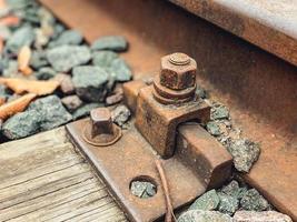 old, abandoned railroad. the rails are fixed with strong metal bolts to the ground. rusty structure for the passage of trains on the road photo