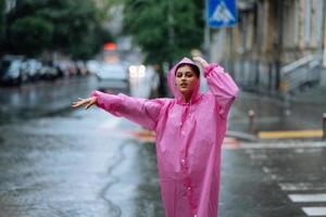 Young girl trying to stop a cab. Woman calling a taxi on a rainy day. photo