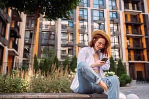 señorita sentada escaleras dispositivo de escritura fuera de la calle de la ciudad urbana foto