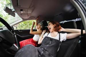 mujeres jóvenes en un viaje por carretera viajando en un automóvil. foto