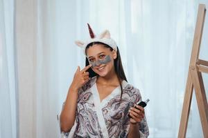 mujer aplicando máscara facial en su cara. concepto de cuidado de la piel foto