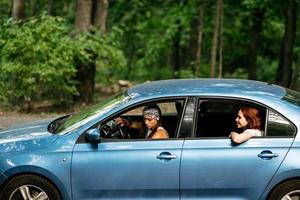 Two girlfriends fool around and laughing together in a car photo