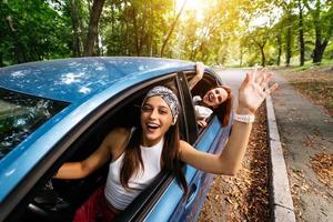 dos amigas se divierten y se ríen juntas en un auto foto