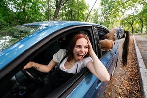 Two girlfriends fool around and laughing together in a car photo